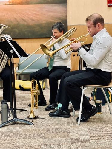 Two men playing trombone and trumpet.